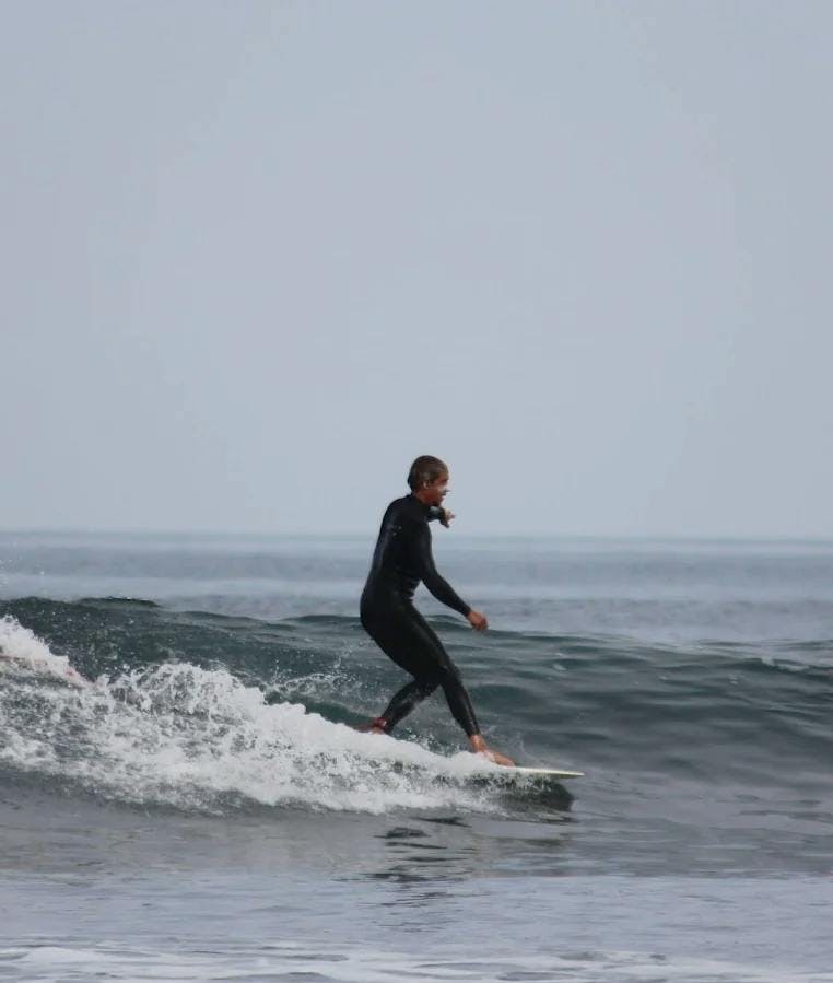 Surfer hanging five in a green wave